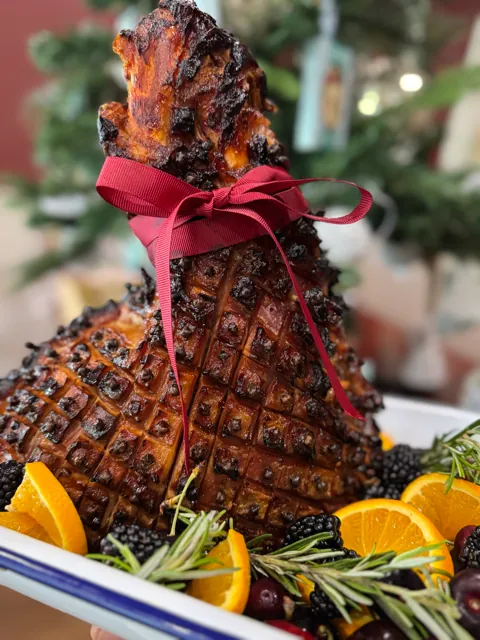 A glazed half ham with orange and rosemary