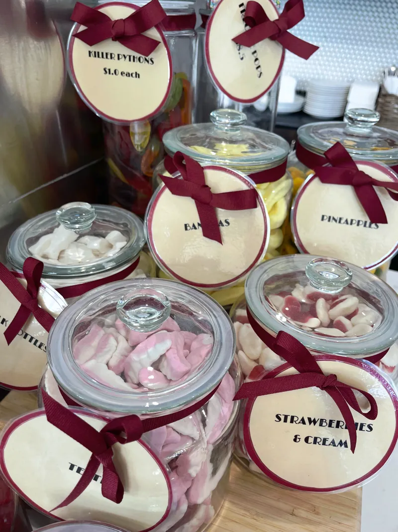 Glass lolly jars tied with burgundy ribbon on the counter