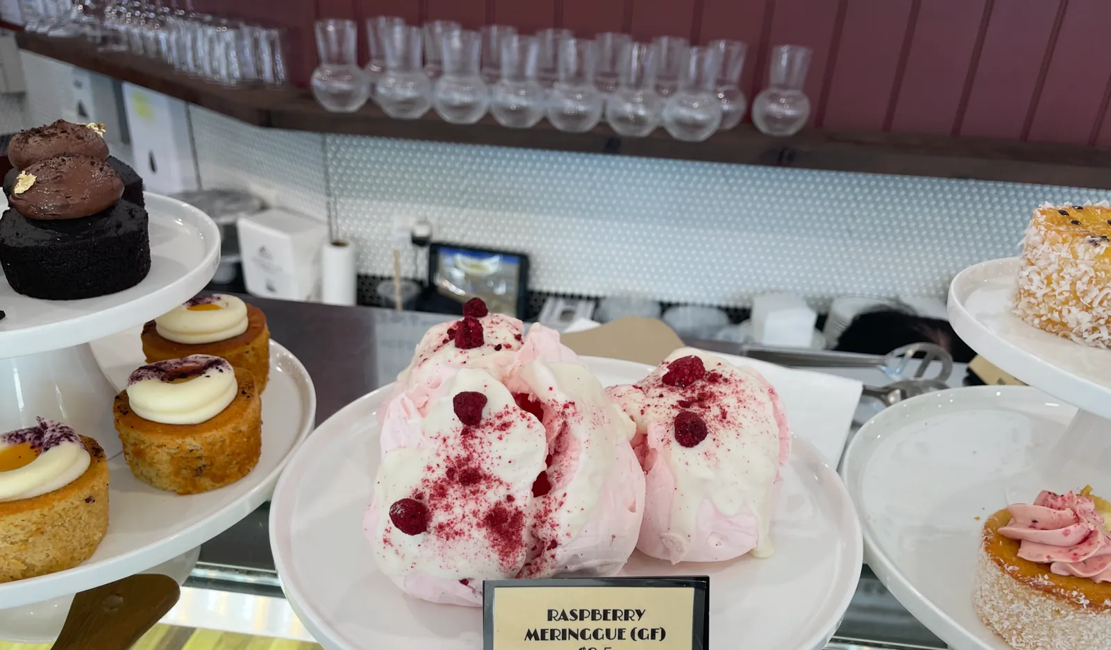 Raspberry meringues on cake stands in the cabinet